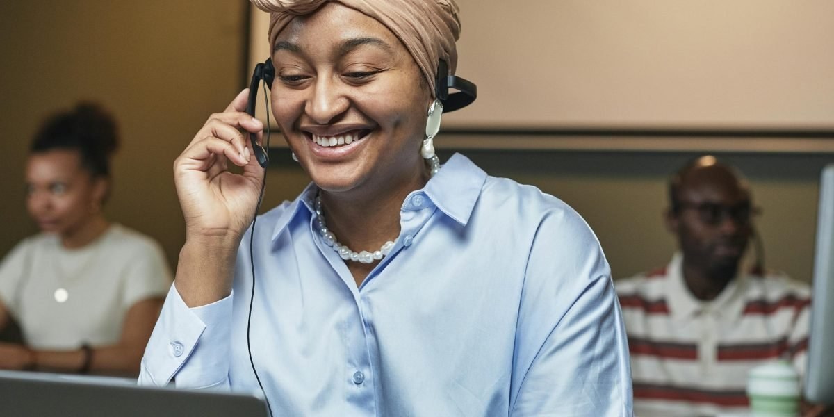 Person speaking on a headset with CRM visible on a laptop screen